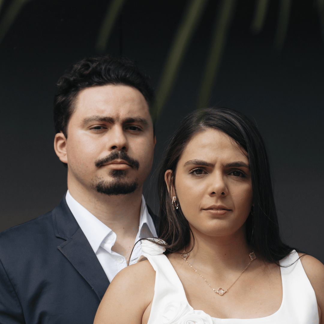 Jonatas e Amanda, lado a lado, olhando sérios para a câmera.